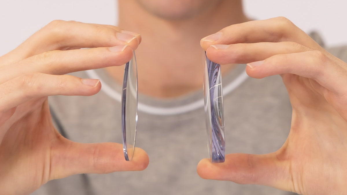 Man holding thick and thin lenses
