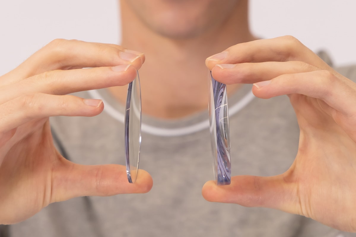 Man holding thick and thin lenses